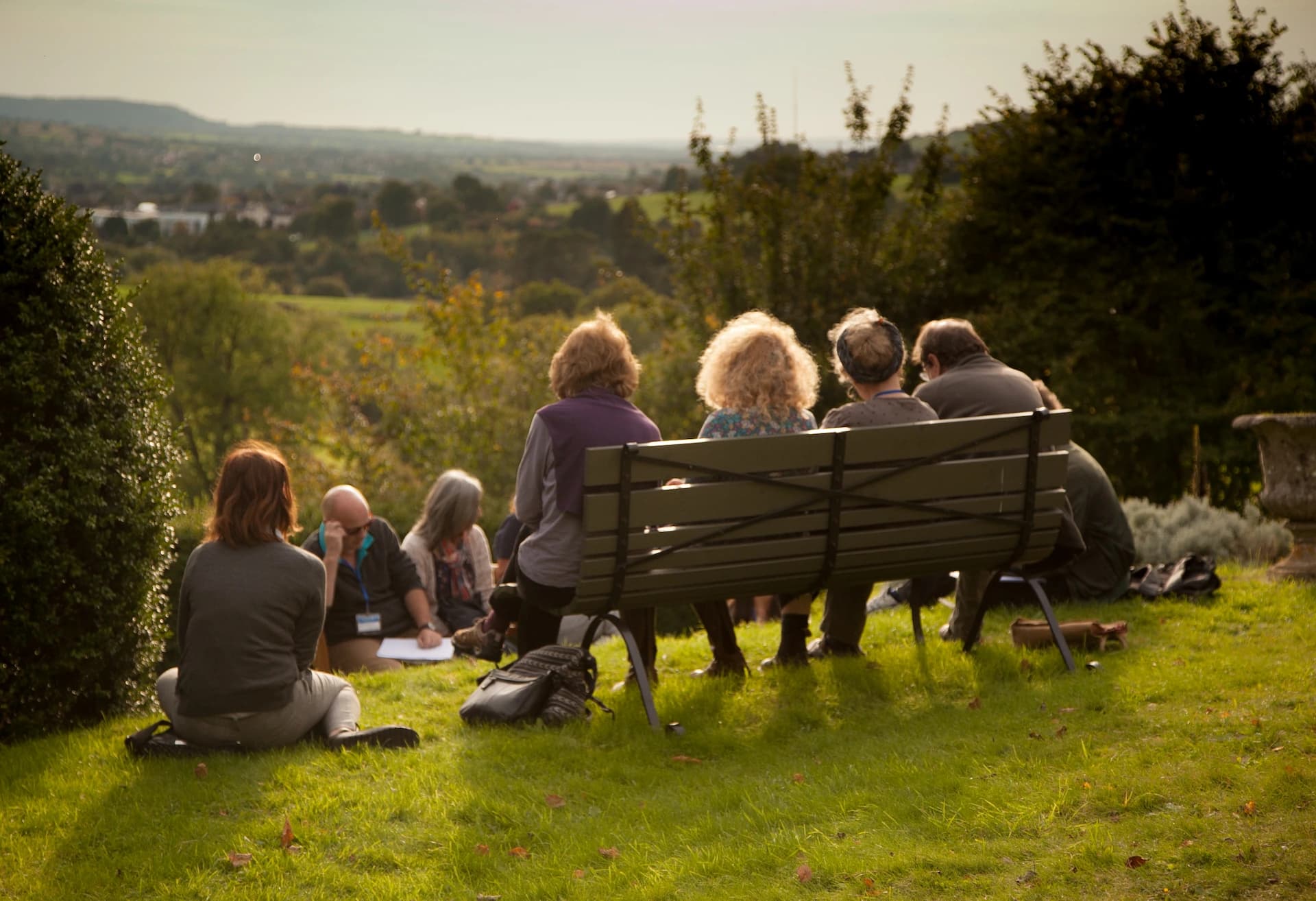 National Landscapes leadership group gathered outdoors overlooking the Cotswolds landscape