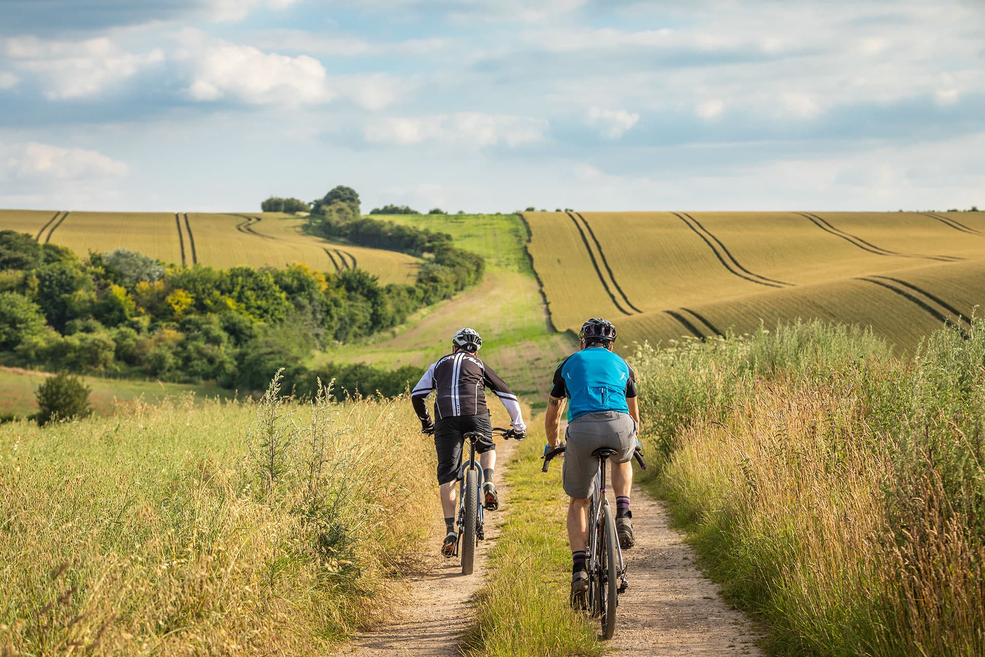 Cyclists on a countryside path through rolling fields in the Chilterns