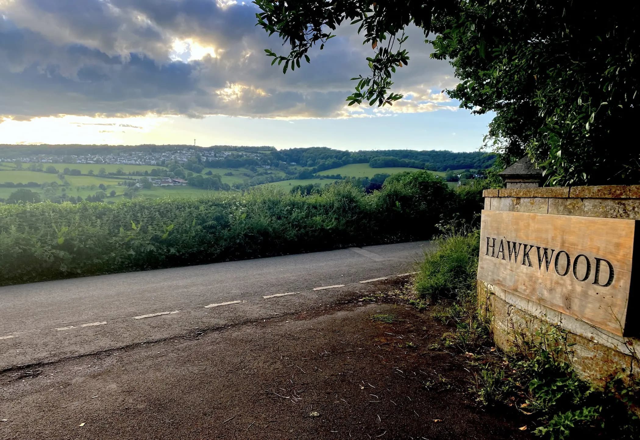 Hawkwood entrance sign with valley view overlooking the Cotswolds landscape